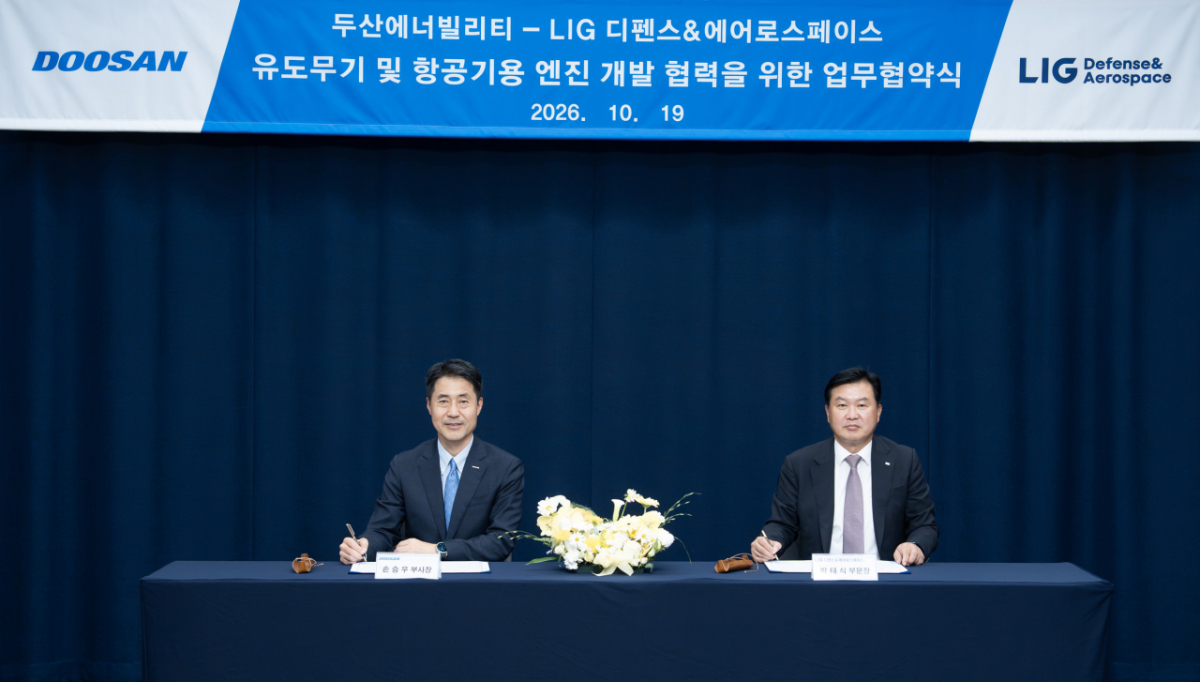 Park Tae-sik, head of the missile systems business at LIG D&A, right, and Son Seung-woo, head of Doosan Enerbility's power services business group, sign an MOU at Doosan Tower in Seongnam, Gyeonggi Province, on Monday. / Courtesy of Doosan Enerbility