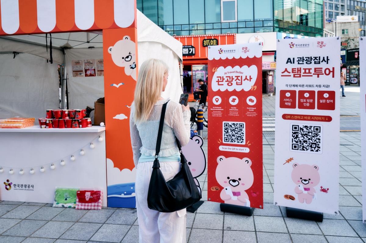 외국인 관광객이 부산 해운대시장에 설치된 'AI 관광집사' 서비스를 이용하고 있는 모습. / 사진제공 = 한국관광공사