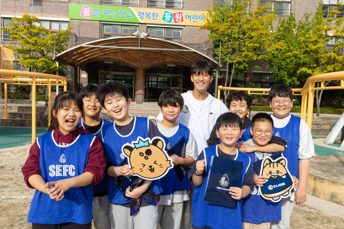 강현제(위)가 지난 19일 서울 강서구 등원초등학교에서 4~6학년 학생 18명을 대상으로 찾아가는 축구 교실 '스마일스쿨' 참가 학생들과 기념 사진을 찍고 있다. /사진=서울 이랜드 제공
