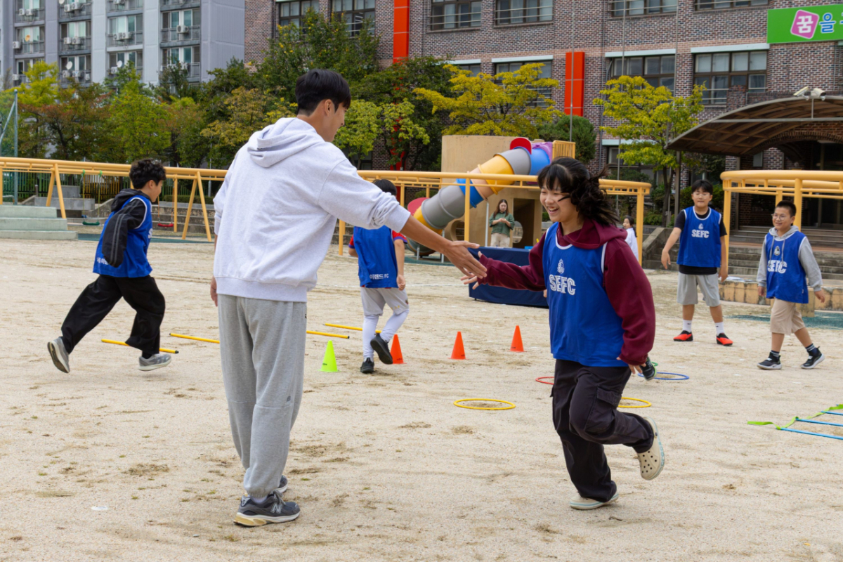 코디네이션을 지도하며 참가 학생과 하이파이브를 나누고 있는 강현제(오른쪽). /사진=서울 이랜드 제공