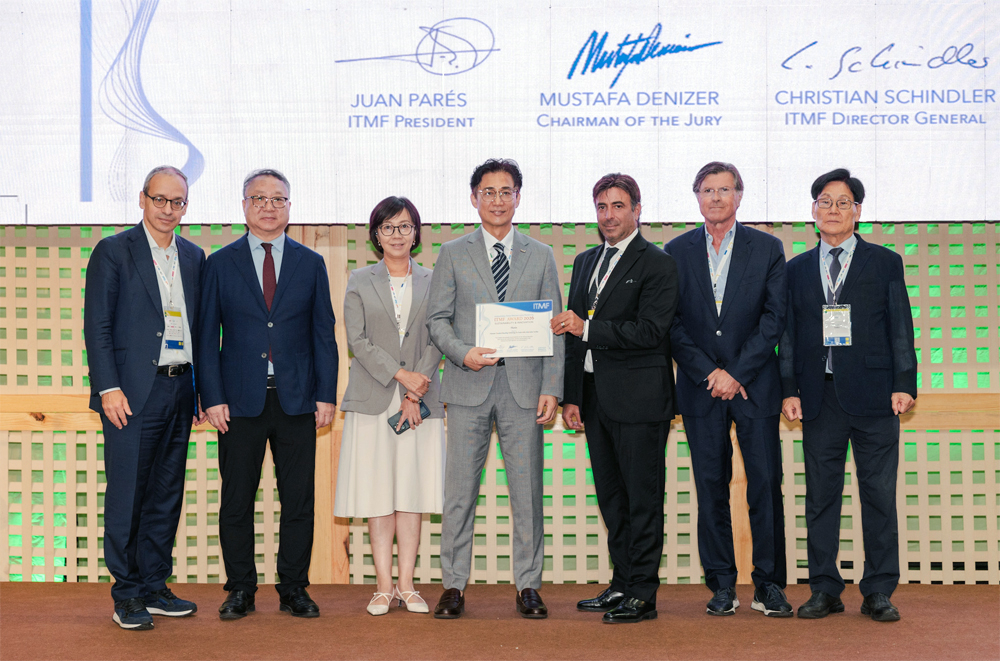이민성 휴비스 연구소장(가운데)이 브라질 포르탈레자에서 열린 '2026 ITMF 어워즈' 시상식에서 수상 후 ITMF 관계자들과 함께 기념촬영을 하고 있다.