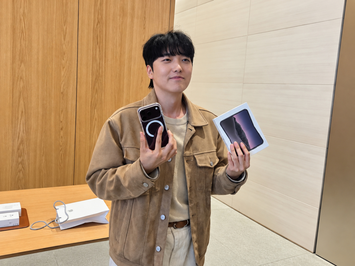 아이폰 듀오 1호 구매자인 박성건씨가 아이폰18 프로와 아이폰 듀오(오른쪽)를 들고 자세를 취하는 모습/사진=구자윤 기자
