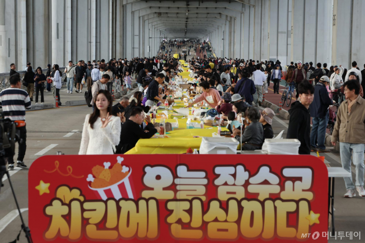 [서울=뉴시스] 김명년 기자 = 25일 서울 잠수교에서 열린 차 없는 잠수교 뚜벅뚜벅 축제의 마지막 행사인 ‘잠수교 치킨데이’에서 시민들이 다양한 브랜드의 치킨을 맛보고 있다. 잠수교는 26일부터 차량 통행이 전면 통제되며 한강 보행전용교 조성을 위한 공사에 들어간다. 2026.10.25. kmn@newsis.com /사진=김명년