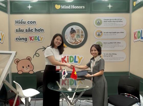 김현진 마인드아너스 대표(왼쪽)와 쩐 티 응아(Tran Thi Nga) Anh Sang Kindergarten 원장(오른쪽)이 지난 10월 16일 베트남 하노이 국제 베이비&키즈페어 현장에서 업무협약(MOU)을 체결한 후 협약서를 들고 기념 촬영을 하고 있다./사진=마인드아너스