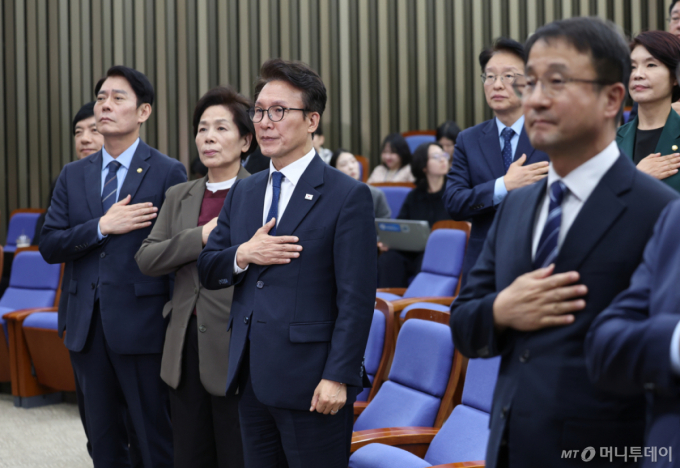 [서울=뉴시스] 김근수 기자 = 김민석 더불어민주당 대표를 비롯한 소속 의원들이 27일 오후 서울 여의도 국회에서 열린 의원총회에서 국민의례를 하고 있다. 2026.10.27. ks@newsis.com /사진=김근수