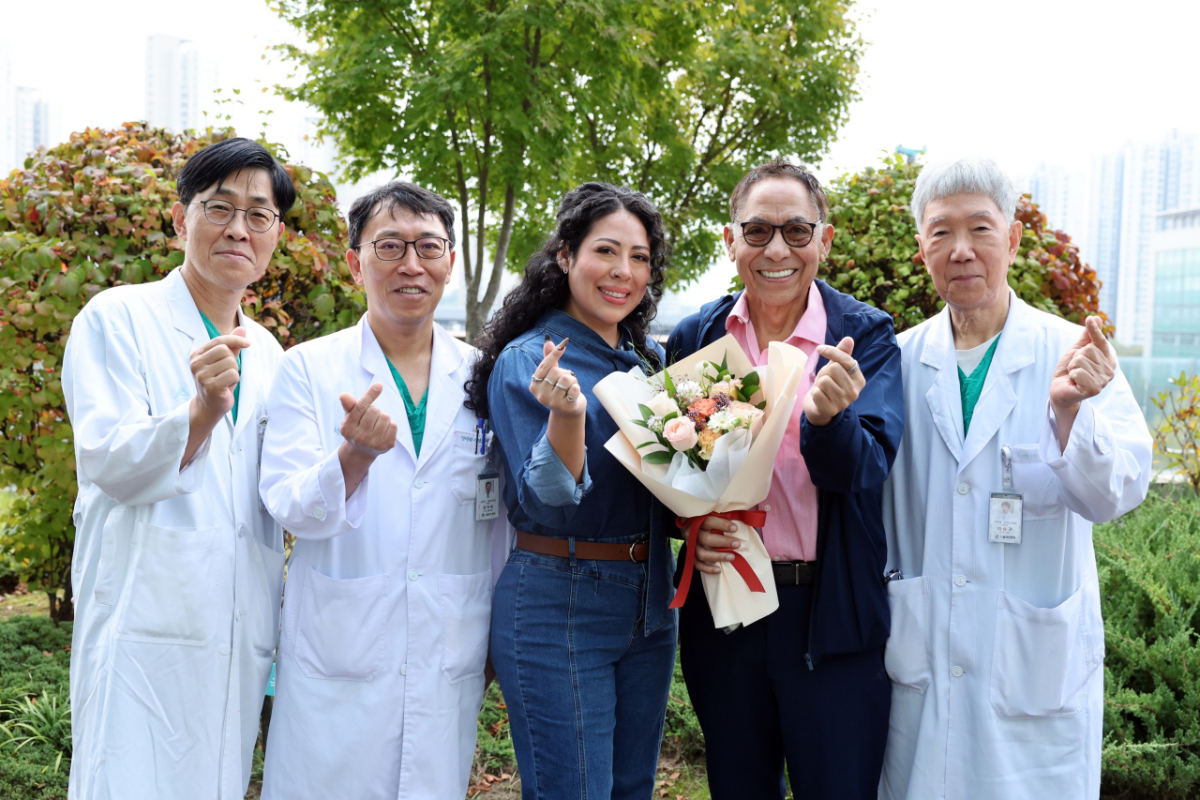 미국인 자선사업가 마르코씨와 딸 킴벌리씨가 귀국을 앞두고 건강한 모습으로 지난 21일 서울아산병원 신관 옥외정원에서 간이식·간담도외과 의료진과 기념촬영을 하고 있다. 왼쪽부터 송기원·문덕복 교수, 기증자인 딸 킴벌리 씨, 수혜자 마르코 씨, 이승규 석좌교수. /사진제공=서울아산병원
