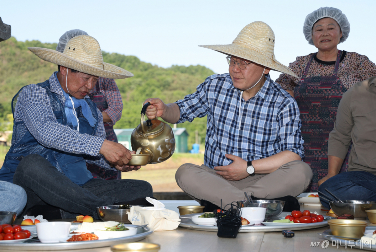 (대구=뉴스1) 허경 기자 = 이재명 대통령이 15일 대구 군위군 소보면 모내기 현장에서 열린 새참 간담회에서 김교묵 도산1리 이장에게 막걸리를 따라주고 있다. 2026.5.15/뉴스1 Copyright © 뉴스1. All rights reserved. 무단 전재 및 재배포, AI학습 이용 금지. /사진=(대구=뉴스1) 허경 기자